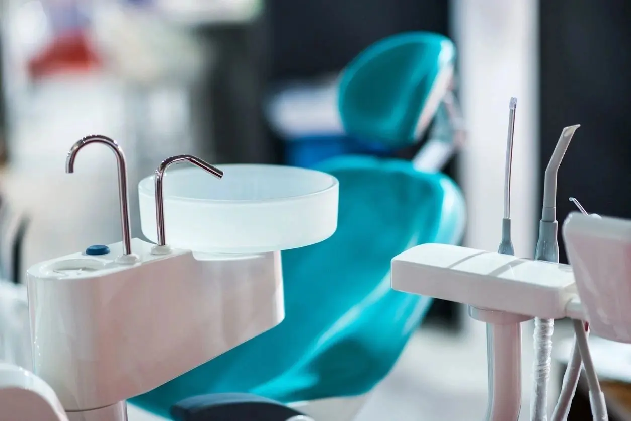 dental tools with a dental treatment chair in background