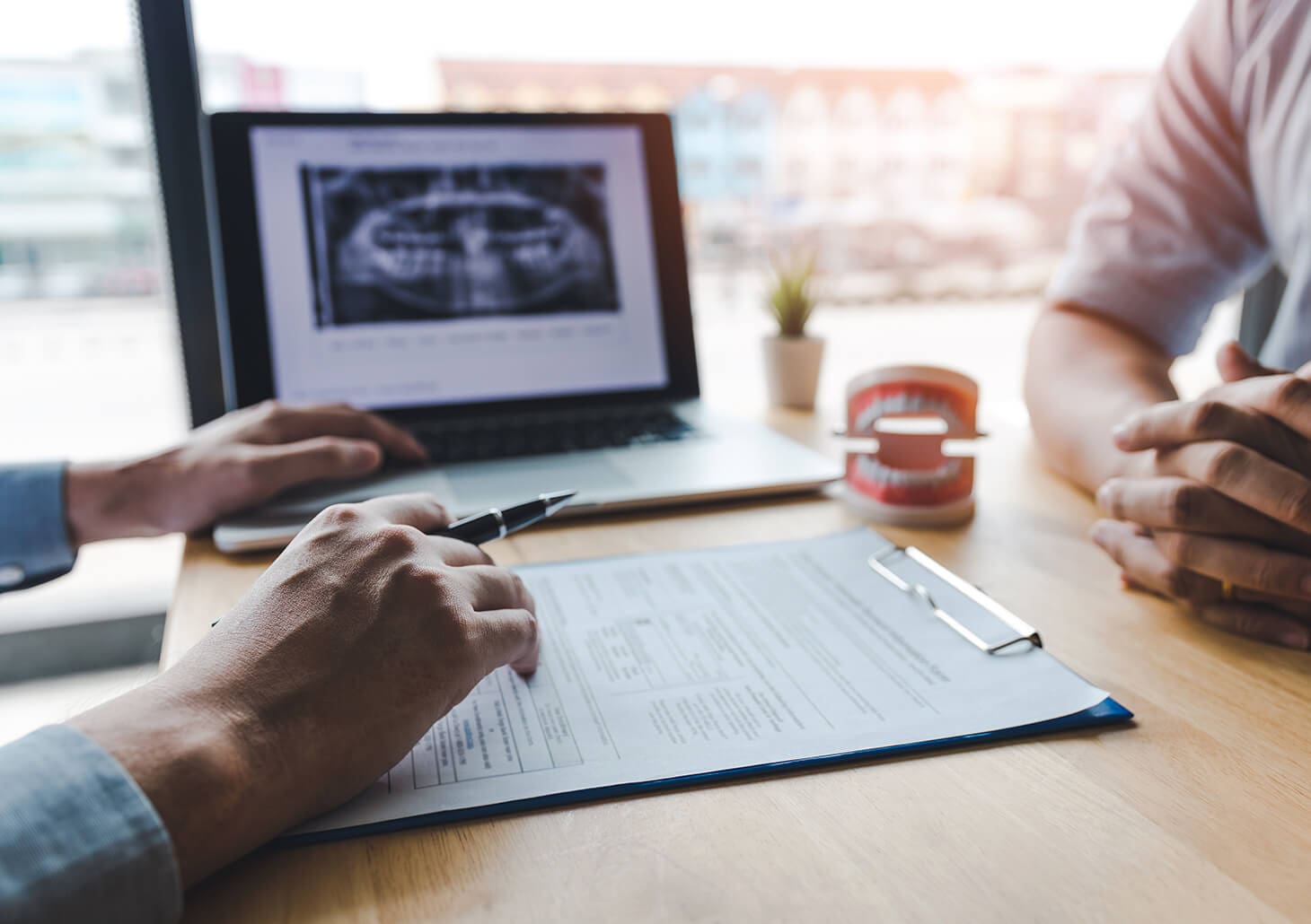 two people discussing dental-related paperwork