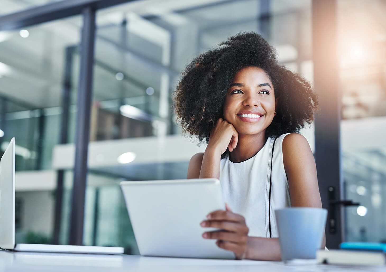 smiling woman sitting in front of a laptop